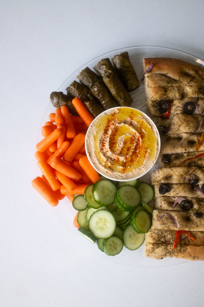 Mediterranean platter with focaccia, hummus, and grape leaves